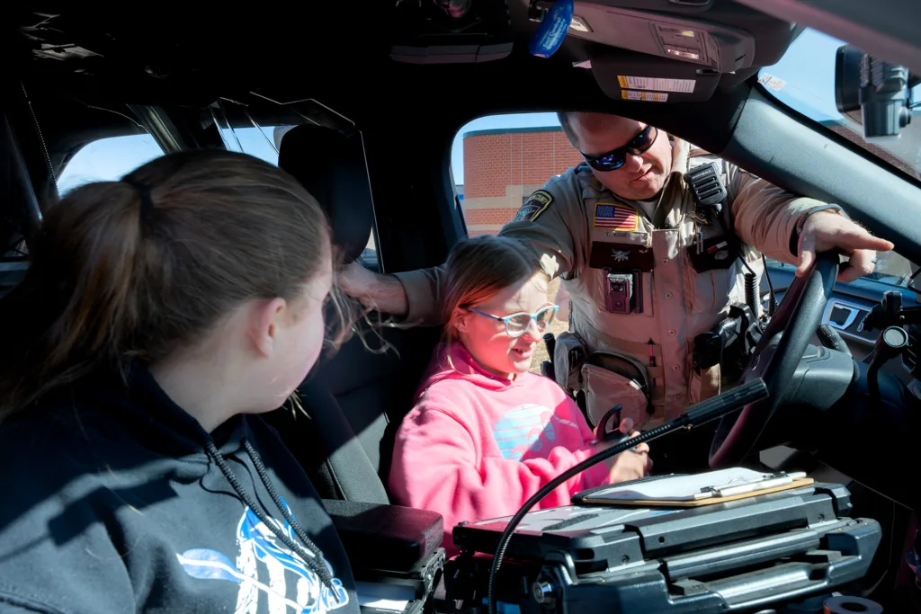 Sheriff officer showing kids a squad car